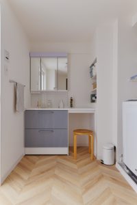 洗面室：リビングのアクセントクロスと統一感のある扉カラー×ヘリンボーン柄のクッションフロアで可愛い北欧テイストに