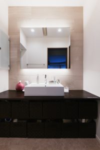 親世帯洗面室：ゲストが使うことも多い洗面はごちゃっとしないようにシンプルに造作。ミラー裏の大判タイルがアクセントのかっこいい空間です。